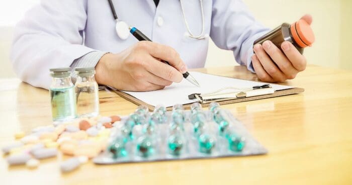 Medications and a stethoscope symbolising drug allergy treatment.