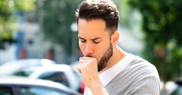 Allergic asthma — Woman using an inhaler outdoors, symbolising the fight against allergic asthma.